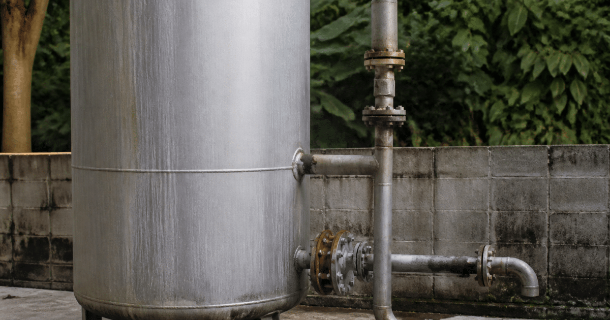 Reservoir metallique vertical avec tuyauteries et soupape de decharge integree
