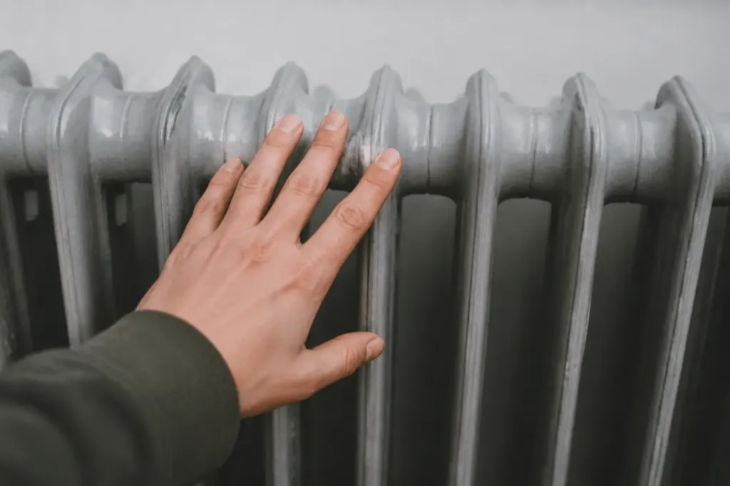 Main touchant radiateur gris metallique refroidi completement