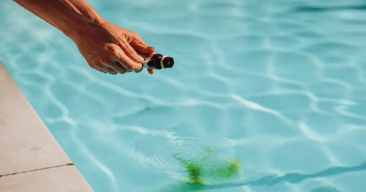 Mains versant produit naturel dans piscine bleue claire