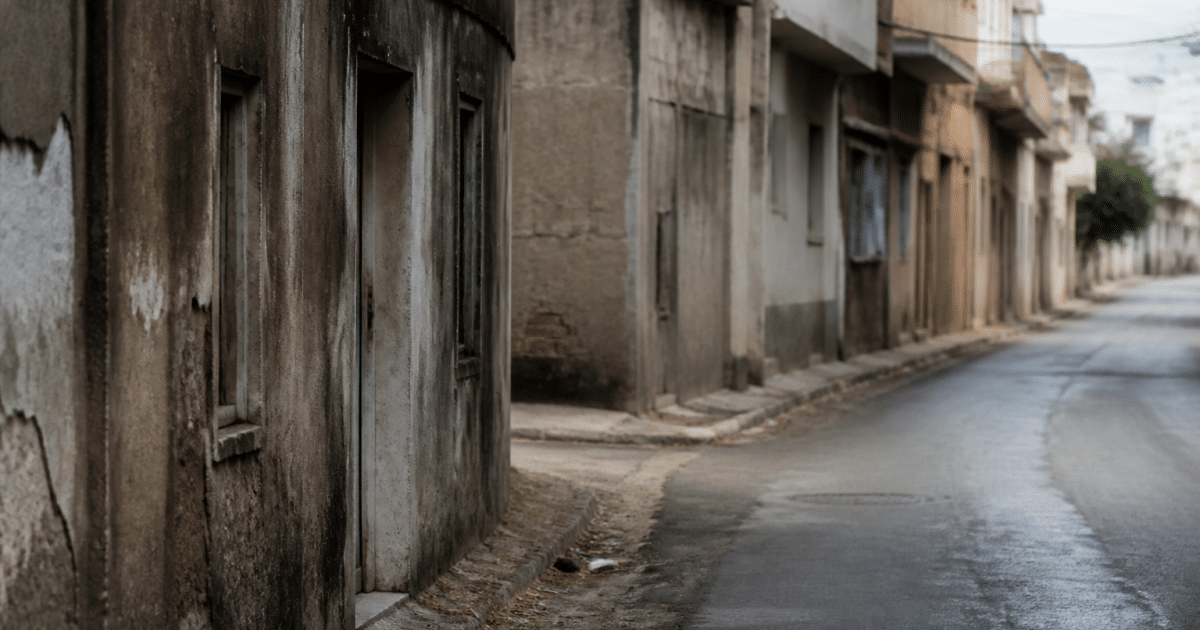 Rue urbaine délabrée avec immeubles deteriores et facades grises ternies