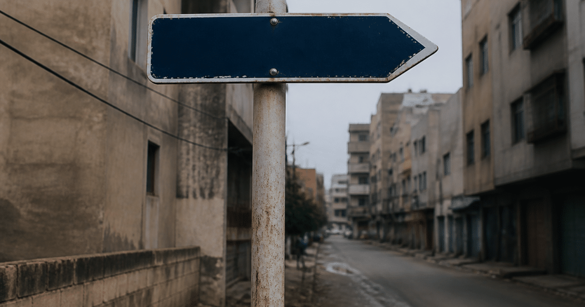 Panneau indicateur de rue pointant vers quartier urbain delabré