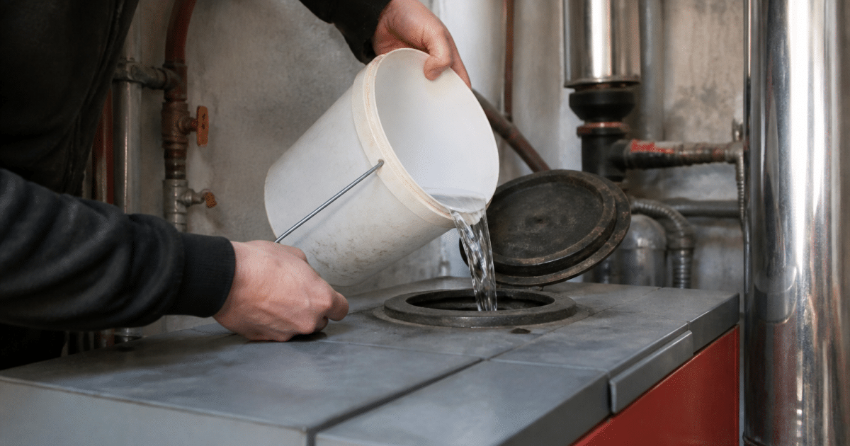 Mains versant eau dans ouverture superieure chaudiere