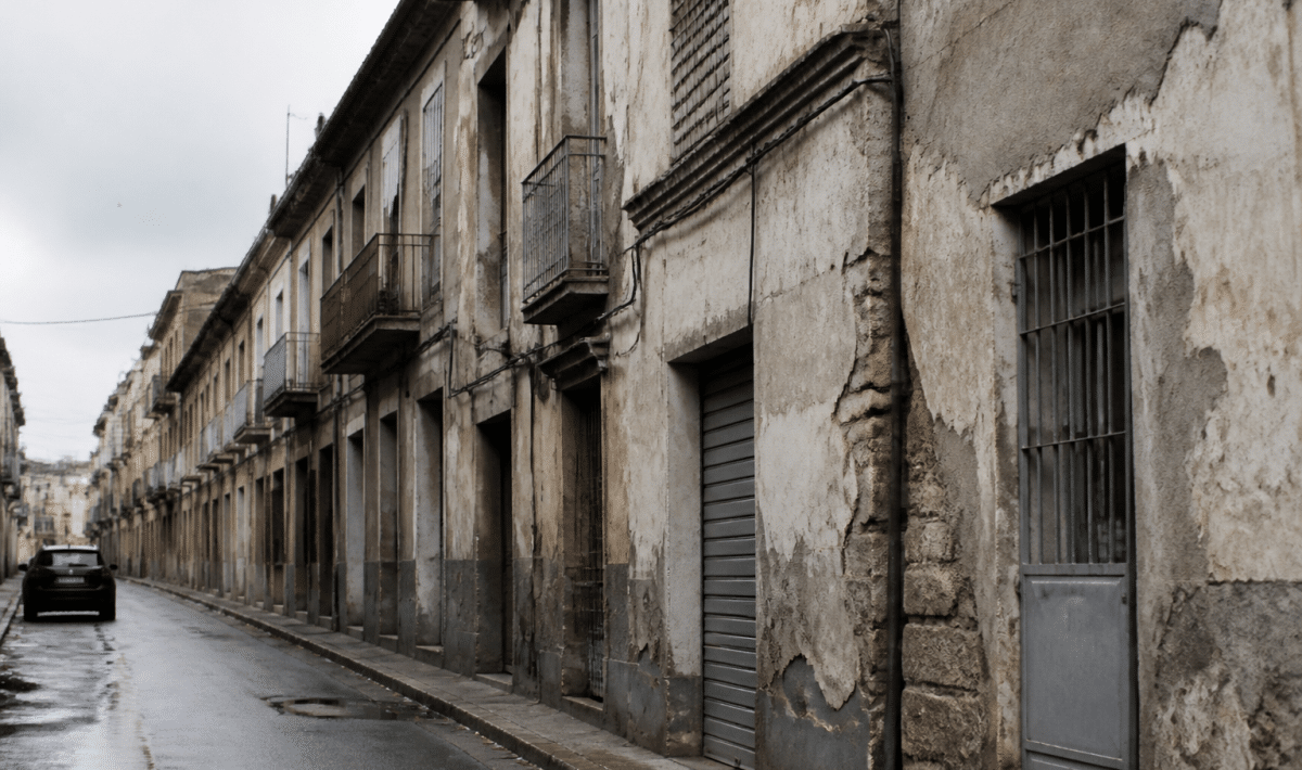 Rue urbaine degradee avec batiments anciens et facades ternies