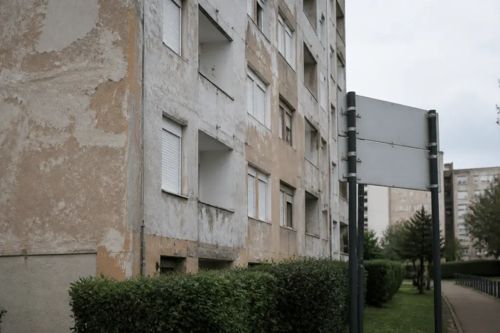 Facade degradee avec panneaux signalisation quartier prioritaire