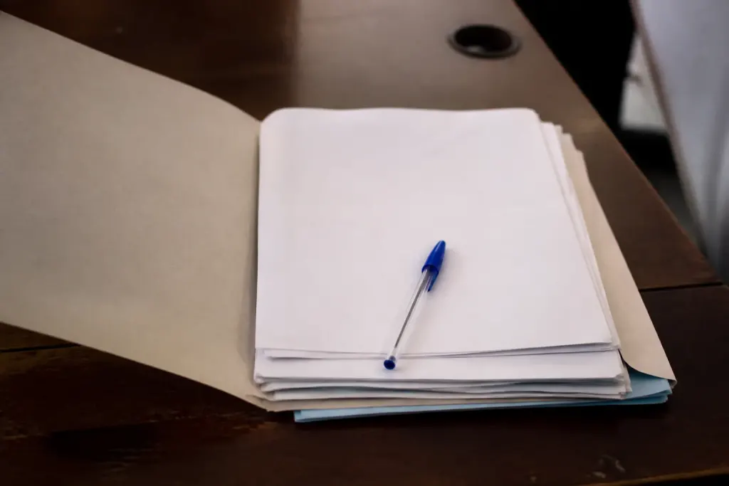 Dossier papier ouvert sur bureau avec stylo bleu