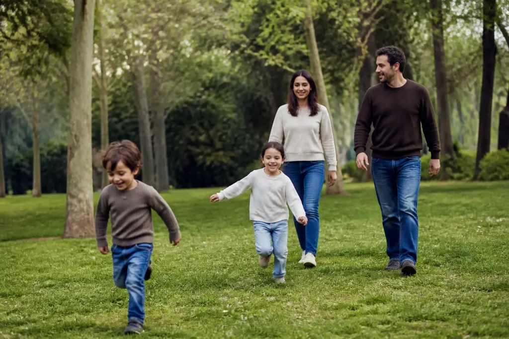 Famille avec deux enfants jouant dans un parc