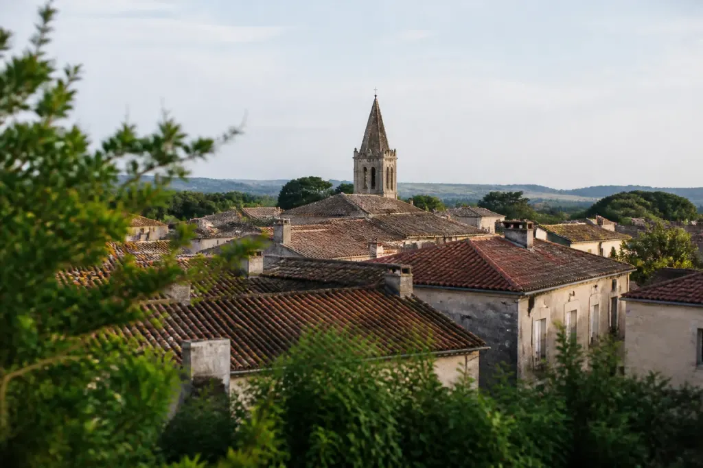 Toits de tuiles et clocher vus depuis une colline